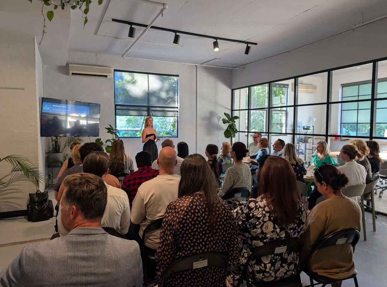 Mia Bowyer running a live AI workshop with a full room of professionals