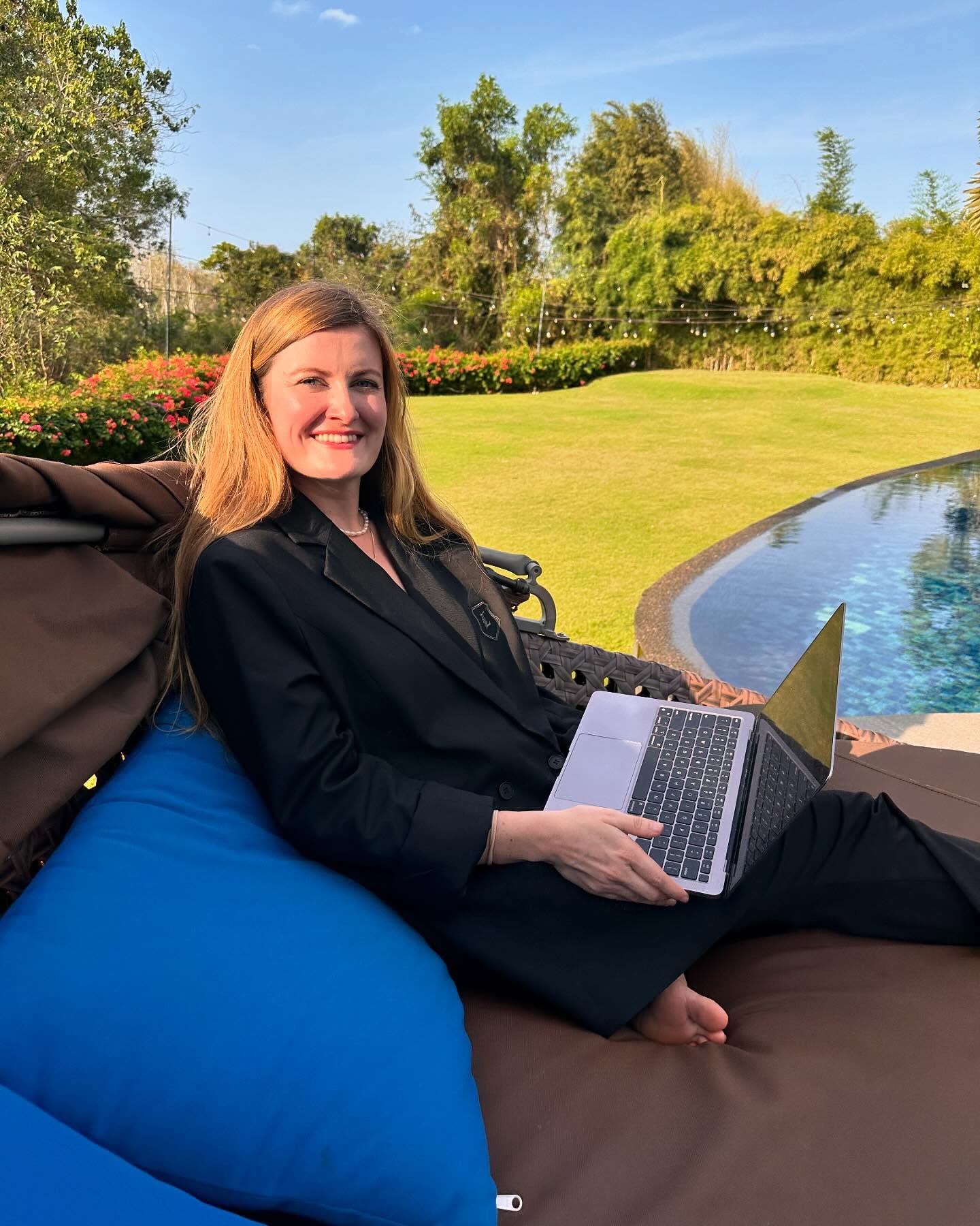 Mia working on her laptop poolside